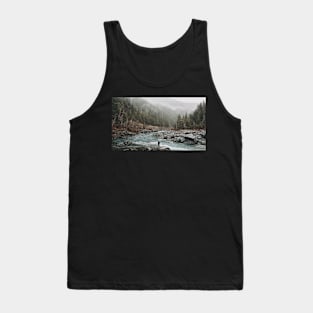 A man standing on jagged rocks in a fast-flowing river in the wilderness Tank Top